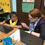 Teacher teaches a student on a computer